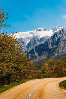 Karla kaplı dağlara doğru giden yolun fotoğrafı. picos de europa Ulusal Parkı.