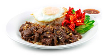 Kızarmış biftek, sarımsak ve biberle karıştırılmış pirinç tarifi üzerine de kızarmış yumurta süslemesi oyulmuş kırmızı biber ve salatalık Thaifood tarzı yan manzara.