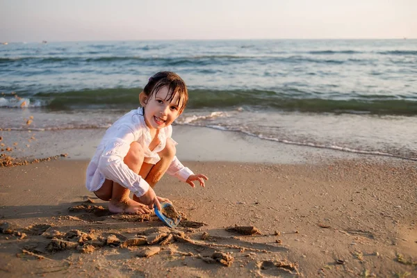 Dítě Evropan sedí na pláži u moře — Stock fotografie