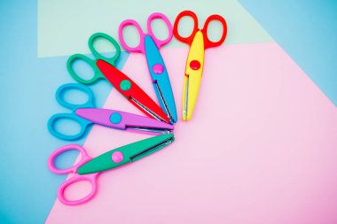 Pembe-mavi arka planda yeni okul malzemeleri. Yukarıdan görüntüle