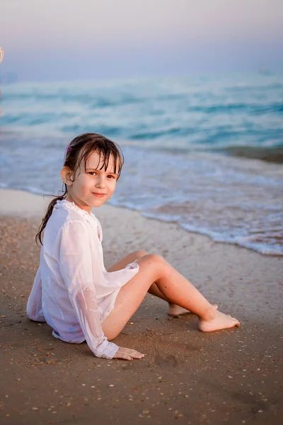 Dítě Evropan sedí na pláži u moře — Stock fotografie