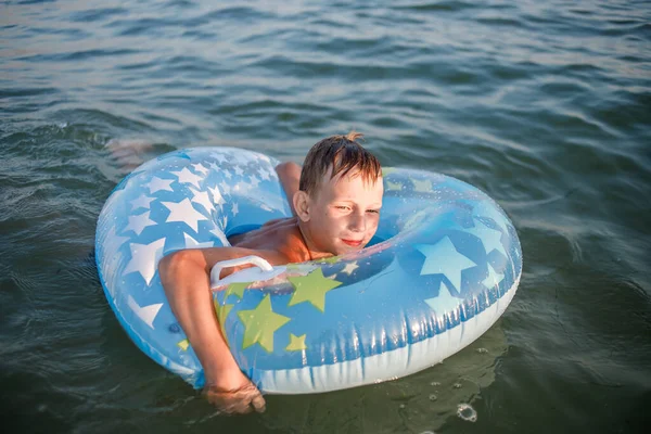 Chlapec s gumovým kroužkem na pobřeží — Stock fotografie