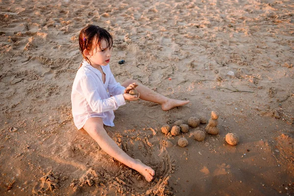 Παιδί Ευρωπαίος κάθεται στην παραλία δίπλα στη θάλασσα — Φωτογραφία Αρχείου