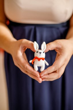 Noel ağacı süslemek için örülmüş bir oyuncağın ellerinde..