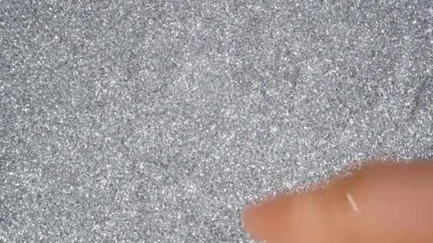 Człowiek ręka narysować serce na świątecznym srebrnym blasku błyszczącej powierzchni — Wideo stockowe