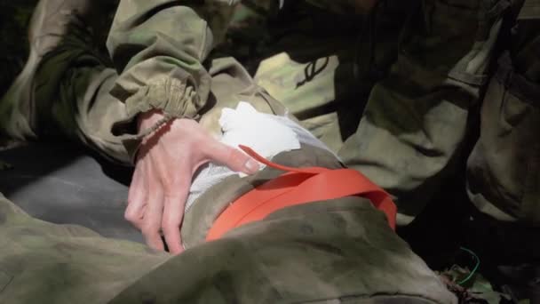 Στρατιώτης Πρώτων Βοηθειών Πόλεμο Γιατρός Παρέχει Bandaging Πληγές Στο Πόδι — Αρχείο Βίντεο