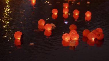 Gölde mumlarla birlikte yüzen kırmızı fenerler. Yüksek kalite 4k görüntü