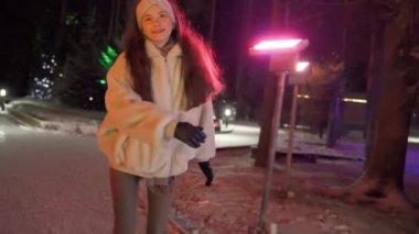 Kız buz pateni yaparken kameraya bakıyor ve el sallıyor. Yüksek kalite 4k görüntü