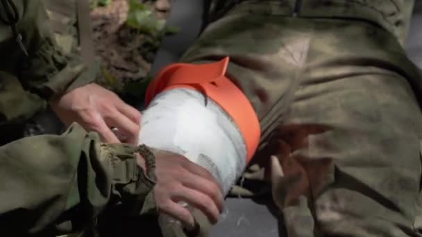 Боевой Медик Обеспечивающий Лечение Раненого Солдата Накладывающий Повязку Ногу Высококачественные — стоковое видео