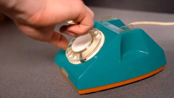 Man picks up the phone and dials a number on a landline phone . High quality photo