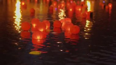 Geceleri suyun üzerinde yüzen kırmızı fenerler. Yüksek kalite 4k görüntü