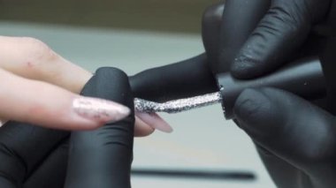 Güzellik salonu kapağındaki çivi müşterisi yakın plan cila çekiyor. Yüksek kalite 4k görüntü