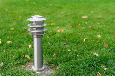 Parktaki yeşil çimlere asılmış zemin sokak lambası. Metin için boşluk kopyala.