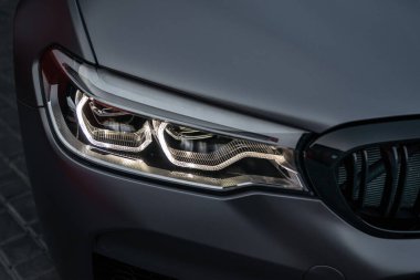 Ukrayna, Odessa 8 Temmuz 2021: Modern prestijli spor araba BMW M5 'in far ışığı. Süper araba ön ışık hattı. Gümüş renkli spor araba.