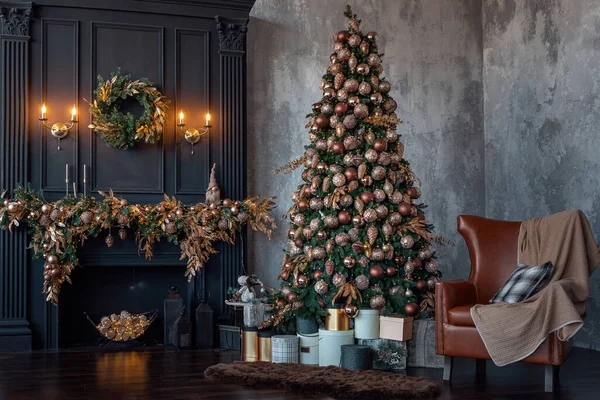 Nagy gyönyörű karácsonyfa díszített arany és bézs fényes baubles és sok különböző ajándékokat. Világító fenyőfa a kandalló mellett otthon. Szilveszter és tél ünnep koncepció Stock Kép