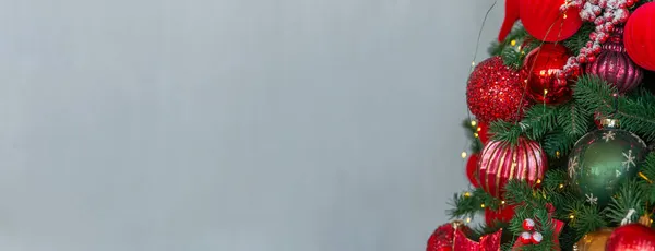 Capodanno Home Albero di Natale con ornamenti rossi e verdi su sfondo grigio. 2022 Buon Natale e Capodanno sfondo vacanze. Spazio vuoto per il testo. Banner, panorama. — Foto Stock