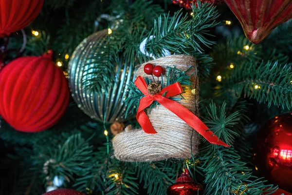 Primo piano Calzino giocattolo di Babbo Natale con fiocco rosso sul ramo dell'albero di Natale. Natale e giocattoli di arredamento di anno nuovo su un abete. — Foto Stock