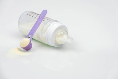 Bebek sütü şişesi beyaz masada. Yeni doğan bebekler için süt tozu. Boşluğu kopyala