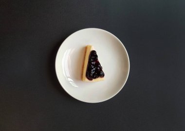 Beyaz tabakta yaban mersinli cheesecake 'in üst görüntüsü ya da fotokopi alanı olan tabaklar. Tatlı atıştırmalık ya da bir parça tatlı. Meyve kremalı çilekli pasta..