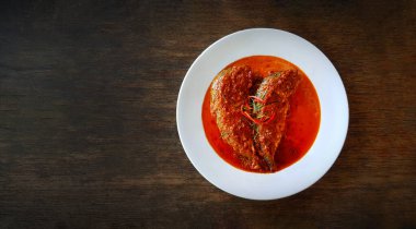 Beyaz tabakta kurutulmuş kırmızı köri soslu taze uskumru ya da Tayland restoranında fotokopi alanı olan ahşap masa. Taylandlılar Choo Chee Pla 'yı da çağırır. Tayland 'da ünlü yiyeceklerin düzlüğü..