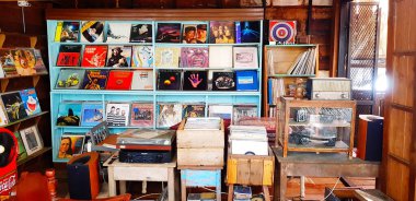 Samut Sakhon, Tayland - 15 Temmuz 2022: Birçok plak veya tabak satılık ahşap rafa kondu. Vintage nesne koleksiyonu ve cam dolapta klasik kamera. 