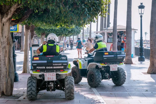 Turist caddesinde bisikletli iki İspanyol polis memuru. Marbella, Malaga / İspanya - 21 Temmuz 2022