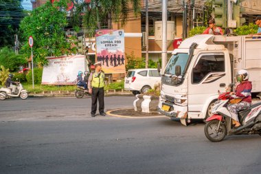 Trafik polisi cadde üzerindeki trafiği kontrol ediyor ve düzenliyor. Denpasar, Endonezya - 8 Ocak 2020