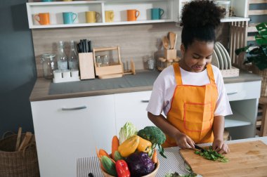 Mutfakta Afro-Amerikan ve sebze salatası olan mutlu çocuk.