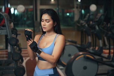 Spor salonunda arka plan eğitim makinesi olan uzay fitness kadını.