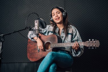 Müzik stüdyosunda gitar çalan güzel bir kadın.