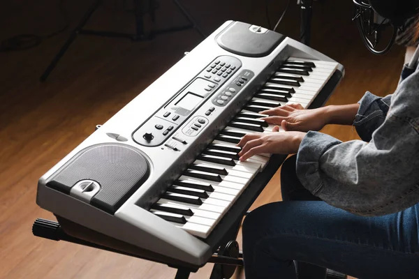 Klavye müziğiyle çalan koyu renk bir kadın eli.