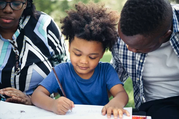 Mutlu eğitim ödevleri, çocuk bahçedeki siyahi aile.