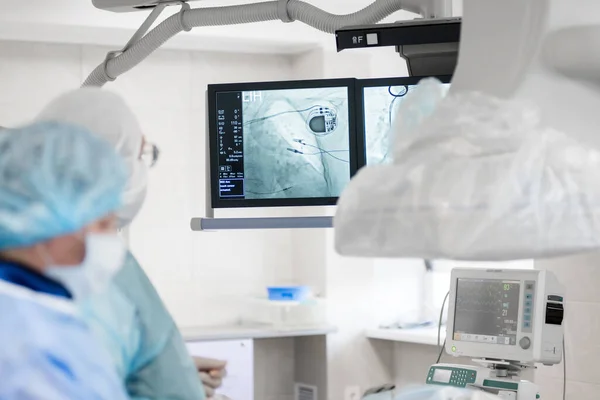 수술실에 전문의는 환자에게 박동기를 엑스레이 모니터를 — 스톡 사진