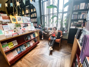 St. Petersburg, Rusya, Ağustos 2021: Eski moda bir kitapçının içi. İki genç hippi kız oturmuş kitap okuyorlar..