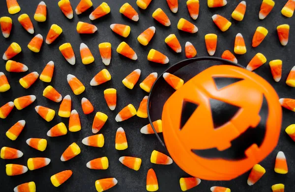 Halloween Background. Candy corn candies, pumpkin basket. Traditional sweet Treats. Copy space.