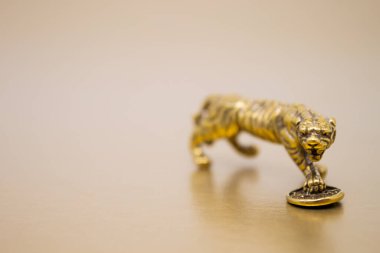 Madeni parası olan bir kaplanın bronz figürü. 2022 yılındaki Çin Yeni Yılı 'nın sembolü. Altın arka planda, kopyalama uzayı. İyi şanslar, maddi refah ve zenginlik dilekleri..