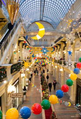 Moskova, Rusya, Aralık 2021: Alışveriş merkezindeki parlak renkli Noel dekoru: dev yıldızlar, boncuklar, ay, kar taneleri. Dikey resim.