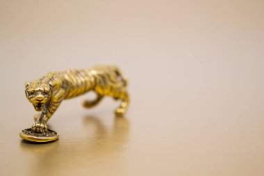 Madeni parası olan bir kaplanın bronz figürü. 2022 yılındaki Çin Yeni Yılı 'nın sembolü. Altın arka planda, kopyalama uzayı. İyi şanslar, maddi refah ve zenginlik dilekleri..