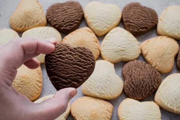 Hand Holds Heart Shaped Chocolate Cookie Backdrop Many Colorful Cookies — Stock Photo, Image