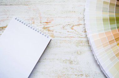 Fan boya örnekleri iç tasarım doğal renkler boyuyor. Ahşap arkaplan, defter, kopyalama alanı.