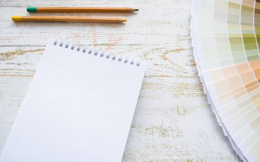 Boya örnekleri iç tasarım doğal renkler. Ahşap arkaplan, defter, kalemler, kopyalama alanı.