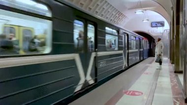 Moskova, Rusya, Aralık 2021: Mayakovskaya İstasyonu. Platformda insanlar gelen treni bekliyor. Tren gelir ve durur.
