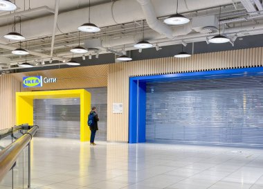 Moskova, Rusya, Mart 2022: Ikea Rusya 'da çalışmaları askıya aldı. Kapalı dükkanın önünde genç bir adam duvarda bilgi okuyor..