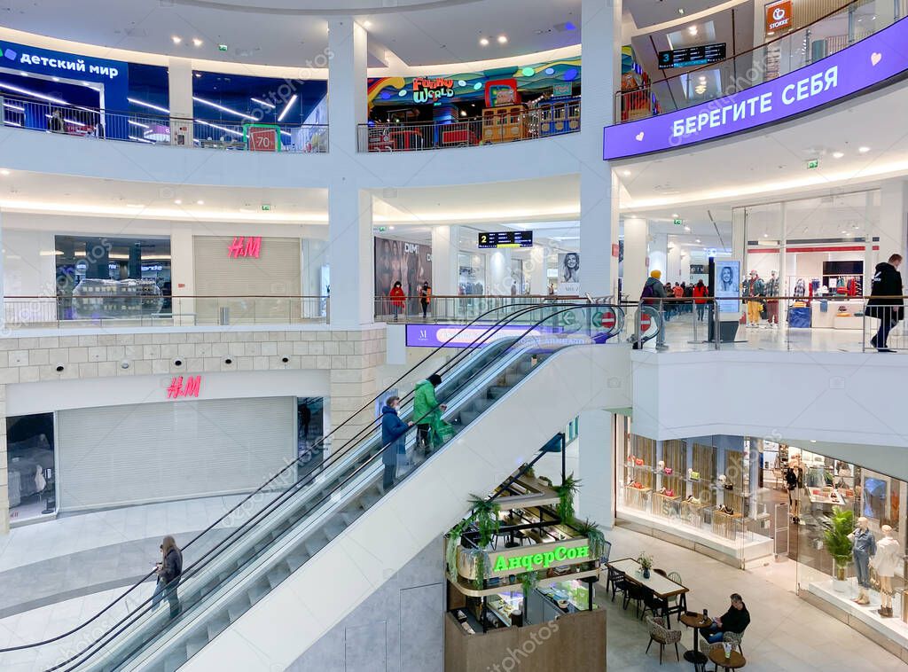 Moscow, Russia, March 2022: HM store suspends work in Russia. Brand shops in the huge shopping mall are closed. Customers are passing by.