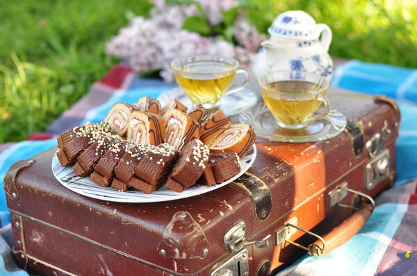 delicious cakes with fillings with two cups of tea on a suitcase