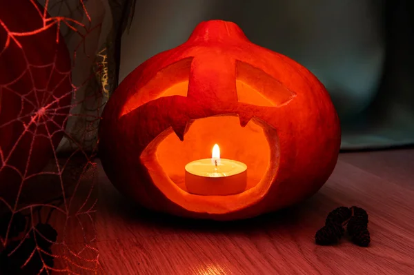Una linterna con una cabeza de calabaza para Halloween, con una vela dentro, una llave baja, una sonrisa aterradora sombría con colmillos. — Foto de Stock