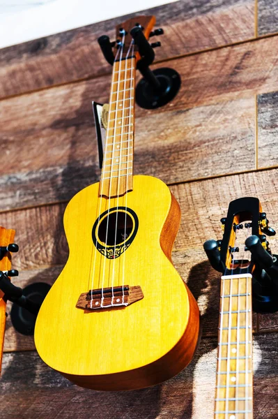 Guitarra de ukelele soprano tradicional amarilla en una pared de madera natural. El concepto de música. — Foto de Stock