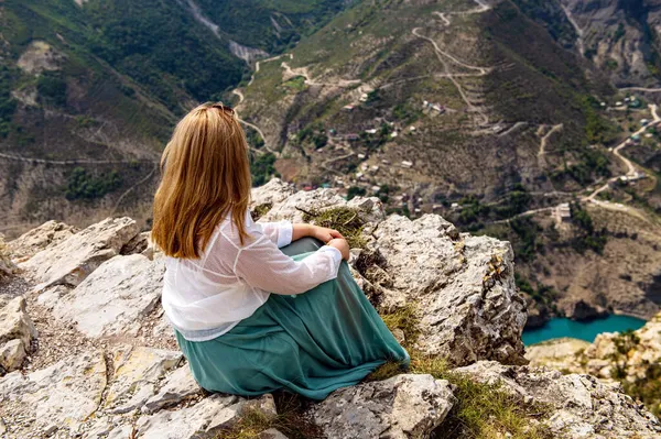Una chica sentada en una roca en un acantilado en el cañón de Sulak, Daguestán — Foto de Stock