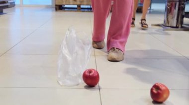 Mağazanın zeminine dökülen elmaların videosu ve bütün elmaları toplayan kadınların elleri..