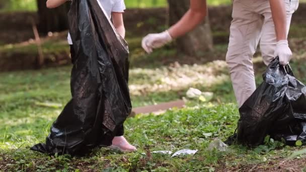Bella ragazza e giovane uomo insieme indossando guanti protettivi in possesso di due borse che raccolgono la spazzatura e dopo che riposano. — Video Stock